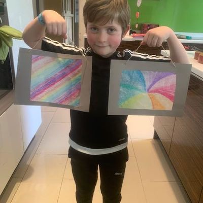 boy holding up pictures